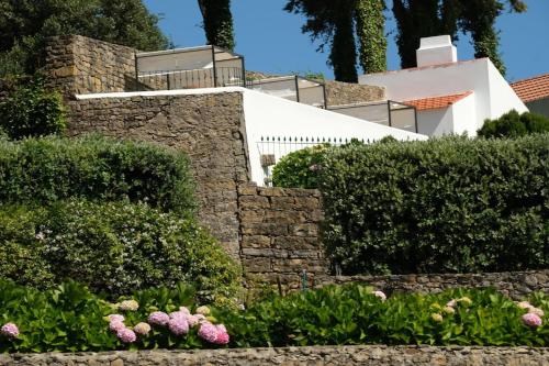 a garden with a stone wall and flowers at Quinta da Maquia Hotel in Sintra