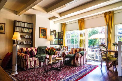 a living room with couches and a table at The Balcony at Prinsen Canal apartment Amsterdam in Amsterdam