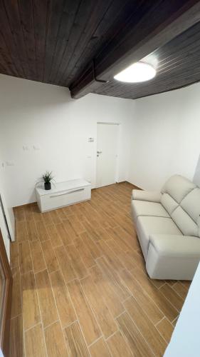 a living room with a white couch and wooden floors at Residenze del Borgo in Zavattarello