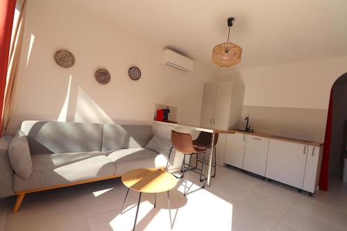 a living room with a couch and a table at T2 Ajaccio- Neuf tout confort- Wifi et Parking gratuit- 5min du centre ville- Proche aéroport et port- secteur Finosello in Ajaccio