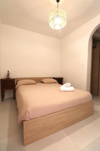 - une chambre avec un grand lit et un lustre dans l'établissement T2 Ajaccio- Neuf tout confort- Wifi et Parking gratuit- 5min du centre ville- Proche aéroport et port- secteur Finosello, à Ajaccio