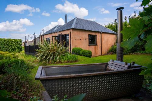 a house with a large tub in front of it at The Artist's House at Jupiter Artland in Kirknewton