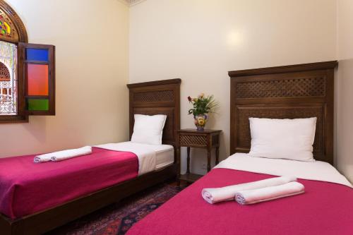 2 Betten nebeneinander in einem Zimmer in der Unterkunft Hotel Atlas in Marrakesch