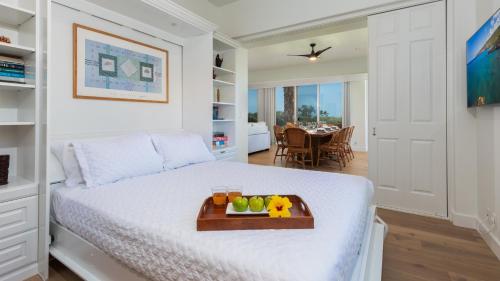 a bedroom with a bed with a tray of fruit on it at PiH: Mauna Kea Horizon Stunning Mauna Kea Resort Ocean Views in Waimea