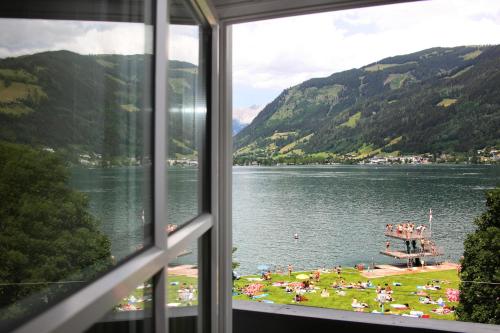 a view from a window of a lake with a beach at Seehotel Sissi in Zell am See