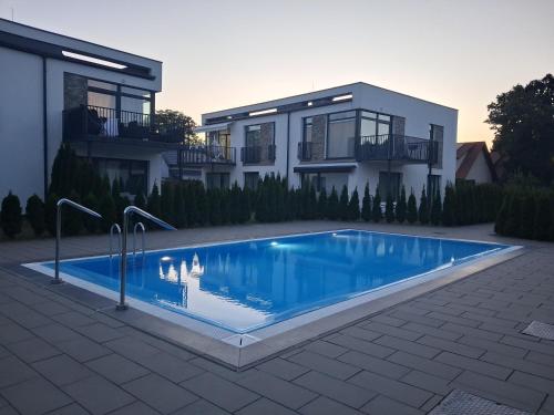 a house with a swimming pool in front of a house at Apartament Glamour 10B- Premium z basenem in Łukęcin