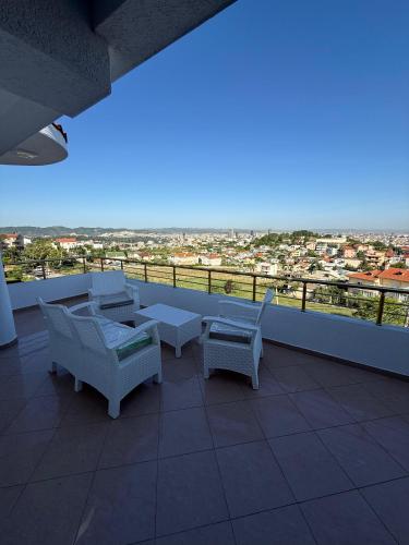 a balcony with chairs and tables and a view of a city at Murati Lake View Hotel in Tirana
