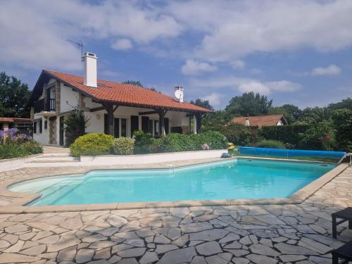une piscine devant une maison dans l'établissement Villa basque piscine chauffée, à Ascain