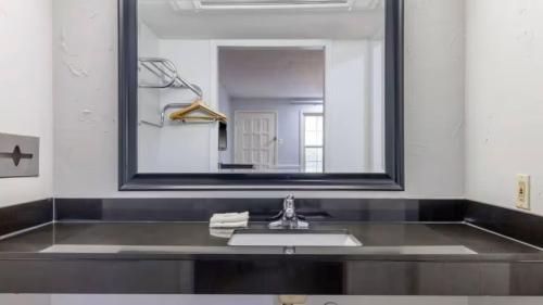 a bathroom with a sink and a large mirror at Suites Dallas TX Downtown in Dallas