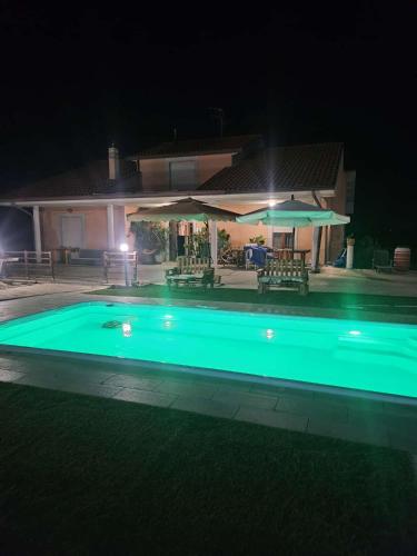 a swimming pool in front of a house at night at Villa Marusia in Tollo