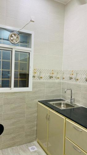 a kitchen with a sink and a window at شقق القبس كرشاء in Ma‘mad