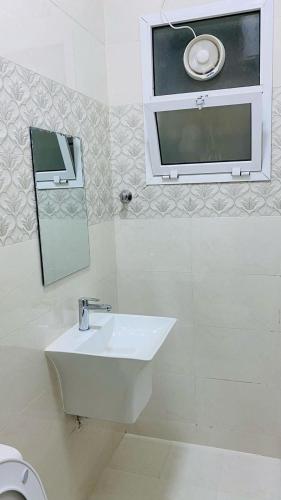 a white bathroom with a sink and a mirror at شقق القبس كرشاء in Ma‘mad