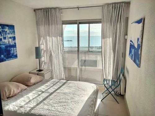 une chambre avec un lit et une grande fenêtre dans l'établissement Bel F2 cabine à Palavas-les-Flots, plage à 2 pas, parking privé - FR-1-559-28, à Palavas-les-Flots