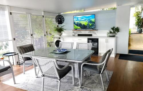 a dining room with a table and chairs and a tv at 270 On Church - Entire Villa with Spacious Alfresco Area in Mudgee