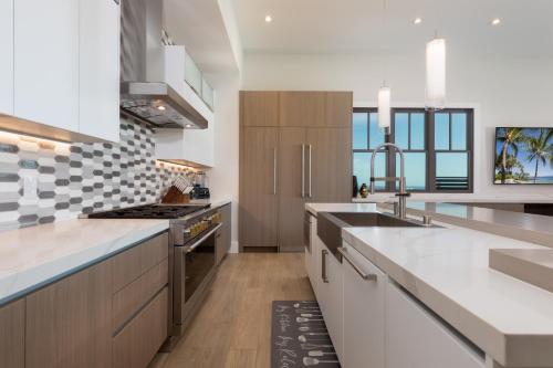 a kitchen with white counter tops and wooden cabinets at PiH: Hale Kailani Heated Private Pool Spa in Waimea