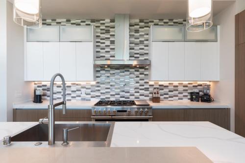 a kitchen with a sink and a stove at PiH: Hale Kailani Heated Private Pool Spa in Waimea