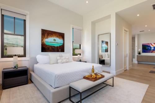 a white bedroom with a bed and a table at PiH: Hale Kailani Heated Private Pool Spa in Waimea