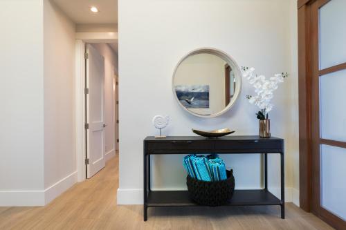 a hallway with a black table and a mirror at PiH: Hale Kailani Heated Private Pool Spa in Waimea