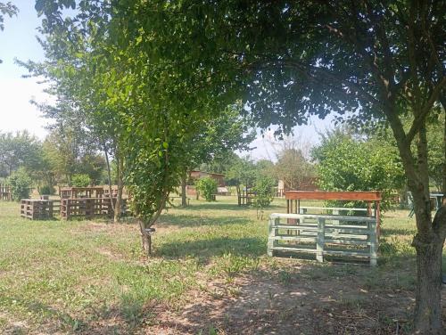 a white fence in a field next to a tree at CASCINA LAI - Oasi Naturalistica - Camere private in Santena