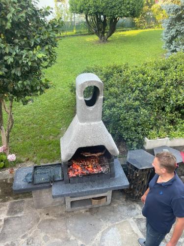 a man standing next to an outdoor grill at LoSteLaDa sul lago di Como in Colico