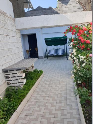 a patio with a bench and some flowers at VIALPI Guest House in Gyumri