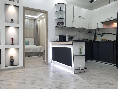 a kitchen with white cabinets and a room with a bed at VIALPI Guest House in Gyumri
