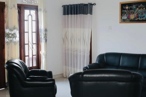 a living room with two leather chairs and a window at VD Rest Gampola in Gampola