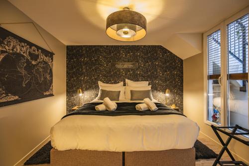 une chambre avec un grand lit avec un mur noir dans l'établissement Domremy HypercentredeReims, à Reims