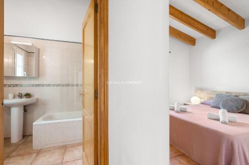 a bedroom with a bed and a bathroom with a tub at Villa Vergara in Cala en Porter