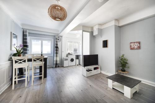 un salon avec une table et une télévision dans l'établissement L'hyper centre terreaux 45m2 équipé CLIM, à Lyon