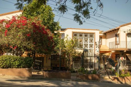 a building with a fence and trees and flowers at Hotel del Monumento in Salta