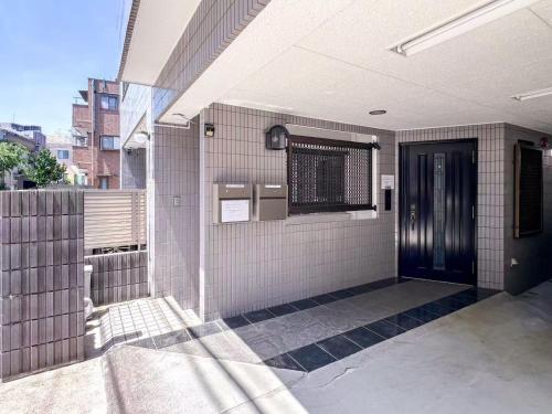 an outside view of a building with a black door at 渡边ビル203 in Tokyo