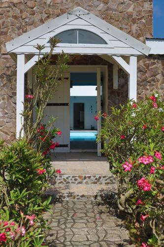 a entrance to a house with a door with flowers at L'Hacienda in Saint-Pierre