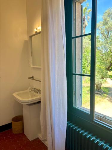 a bathroom with a sink and a window at Villa Magdala Arts & Résidence in Hyères