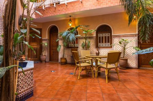 a patio with a table and chairs and plants at Hotel Atlas in Marrakesh