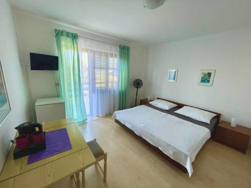 a bedroom with a large bed and a table at Sobe-Sandra in Dramalj