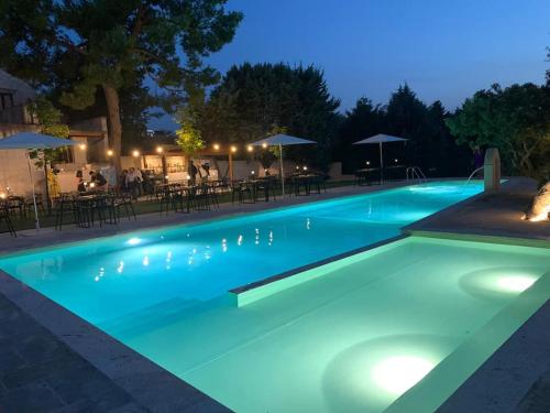 a swimming pool lit up at night at Residence Masseria Santa Lucia in Matera