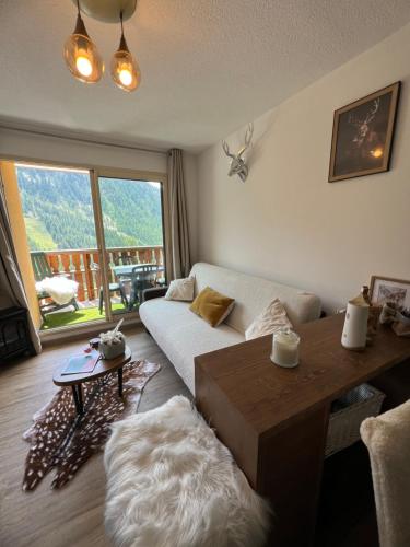 un salon avec un canapé et une table dans l'établissement Plein Centre, sublime et confortable, 6 personnes, 2 chambres, Plein Centre, luxueux 6 personnes, 2 chambres , terrasse, vue époustouflante, Tout pédestre, piste à 100m, parking couvert, à Isola