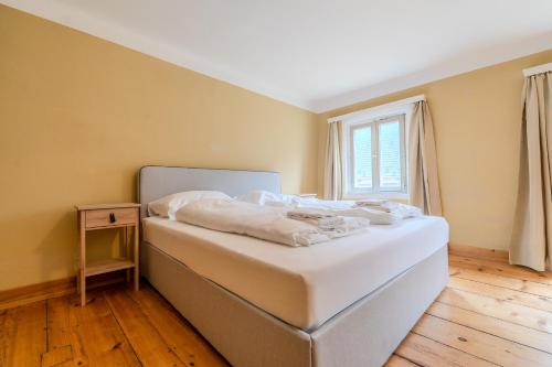 a bedroom with a bed with white sheets and a window at Whats-App Self-Check-IN - Bad Aussee City House in Bad Aussee