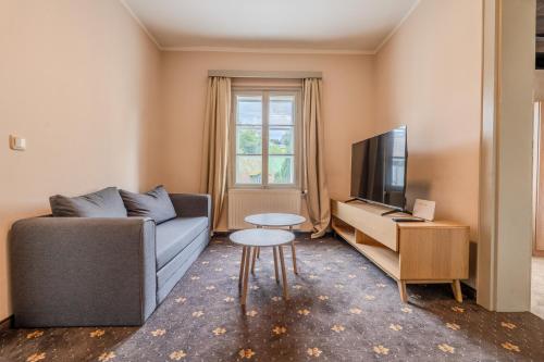 a living room with a couch and a tv and a table at Whats-App Self-Check-IN - Bad Aussee City House in Bad Aussee