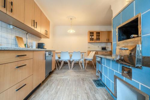 a kitchen with wooden cabinets and blue tiles at Whats-App Self-Check-IN - Bad Aussee City House in Bad Aussee
