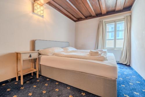 a bedroom with a bed and a table and a window at Whats-App Self-Check-IN - Bad Aussee City House in Bad Aussee