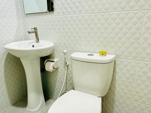 a bathroom with a white toilet and a sink at สวนไมตรีจิต รีสอร์ท in Ban Khlong Si