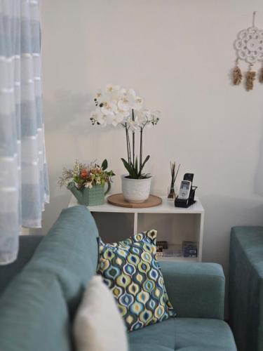 a living room with a blue couch and a table with flowers at Vikendica Fruškogorski kutak - Fruška Gora in Čerević