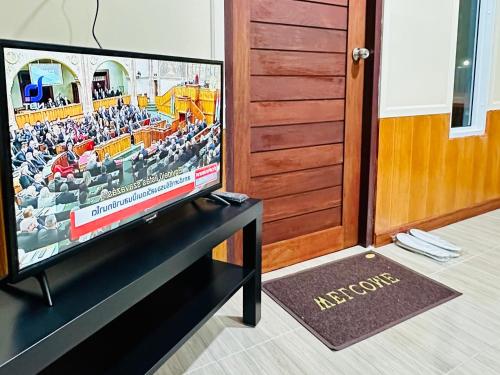 a flat screen tv sitting on a table in a room at สวนไมตรีจิต รีสอร์ท in Ban Khlong Si