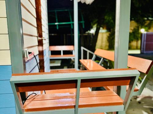 a wooden bench sitting on the porch of a house at สวนไมตรีจิต รีสอร์ท in Ban Khlong Si