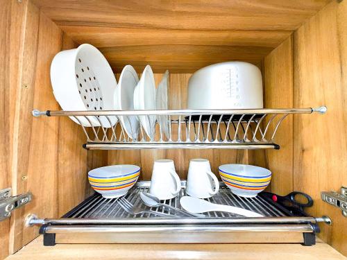 a kitchen rack with dishes and utensils in a cabinet at Apt Vasanta Tokyo2 japanese 1BR in Jarakasta