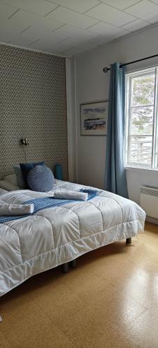 a bedroom with a large bed with a window at Pensar Hotelli & Ravintola Sandvik in Nauvo