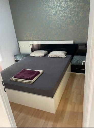 un lit avec deux oreillers dessus dans une chambre dans l'établissement Bel appartement Type F2 vaux en velin Village 69120, à Vaulx-en-Velin