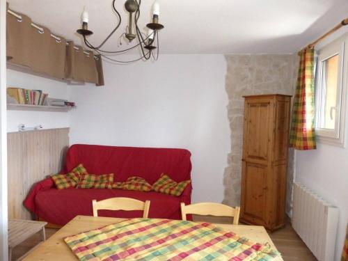 un salon avec un canapé rouge et une table dans l'établissement Studio cabine confortable 4 pers - FR-1-804-21, à Barcelonnette